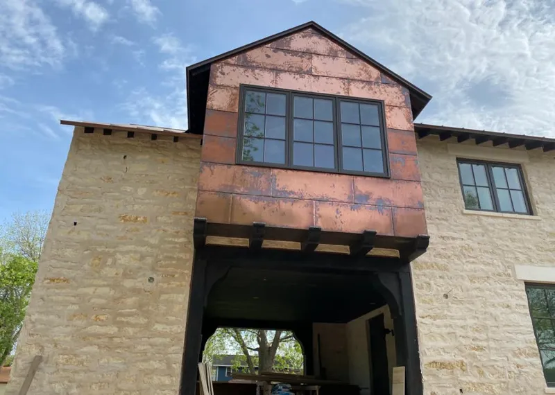 Copper metal panel facade on a stone building for Skylight Installation in Indianola